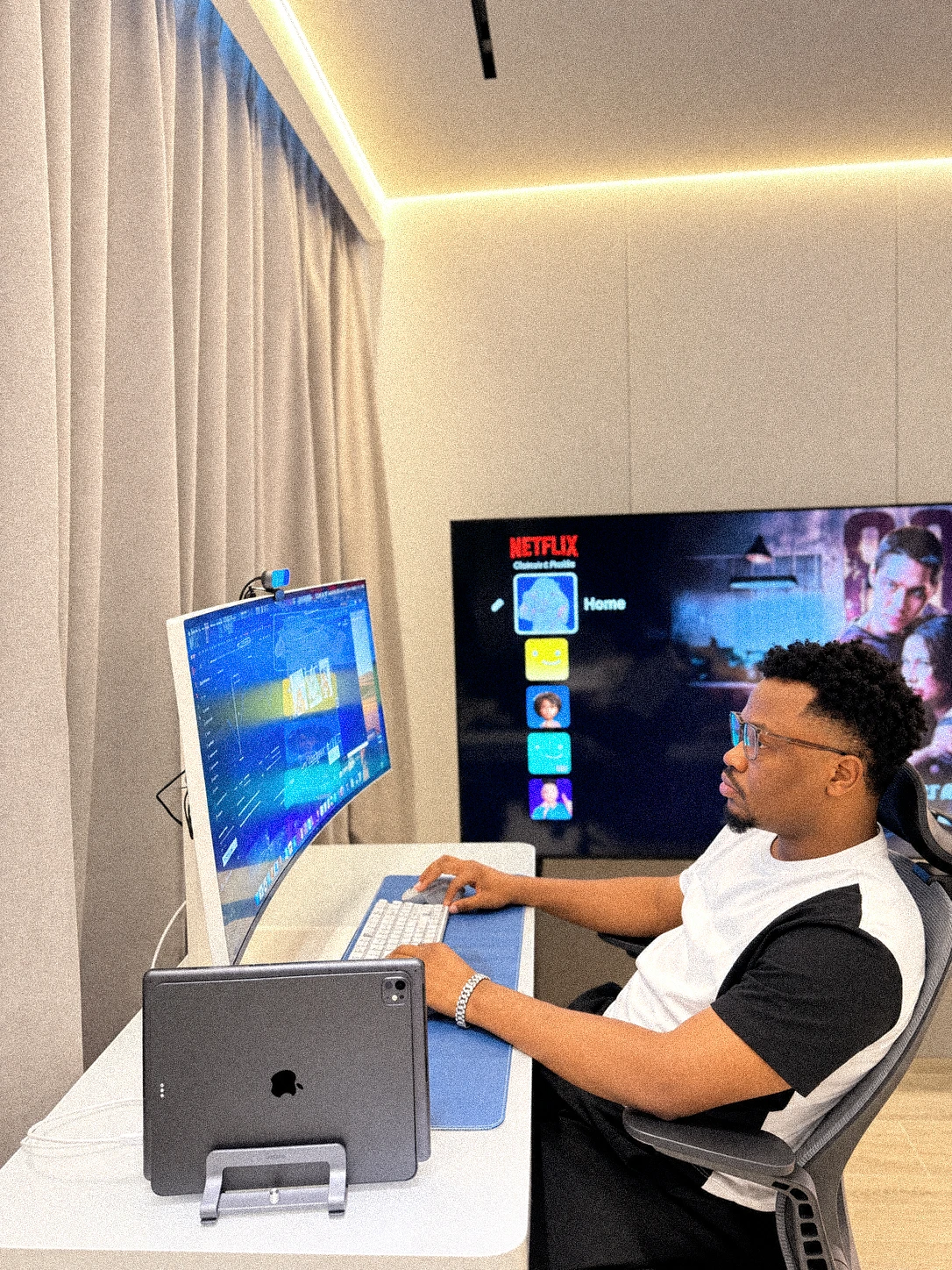 Oluwayemi at his desk, working on a curved monitor